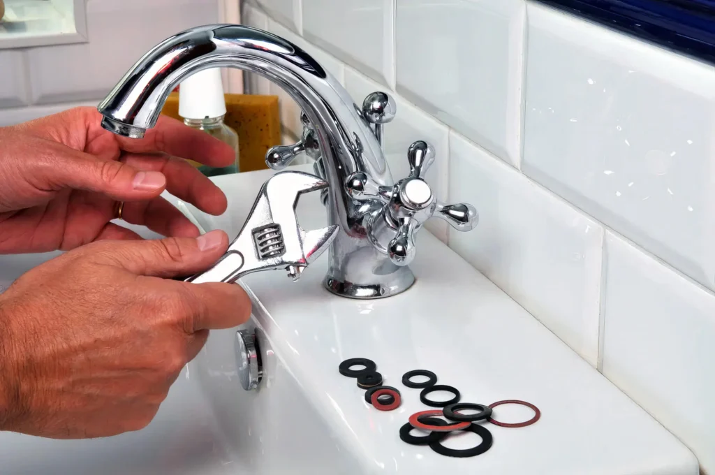 Plumber performing maintenance on a bathroom faucet in DeBary