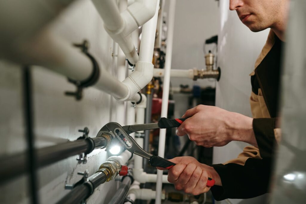 Plumbers maintaining commercial plumbing pipes in DeBary