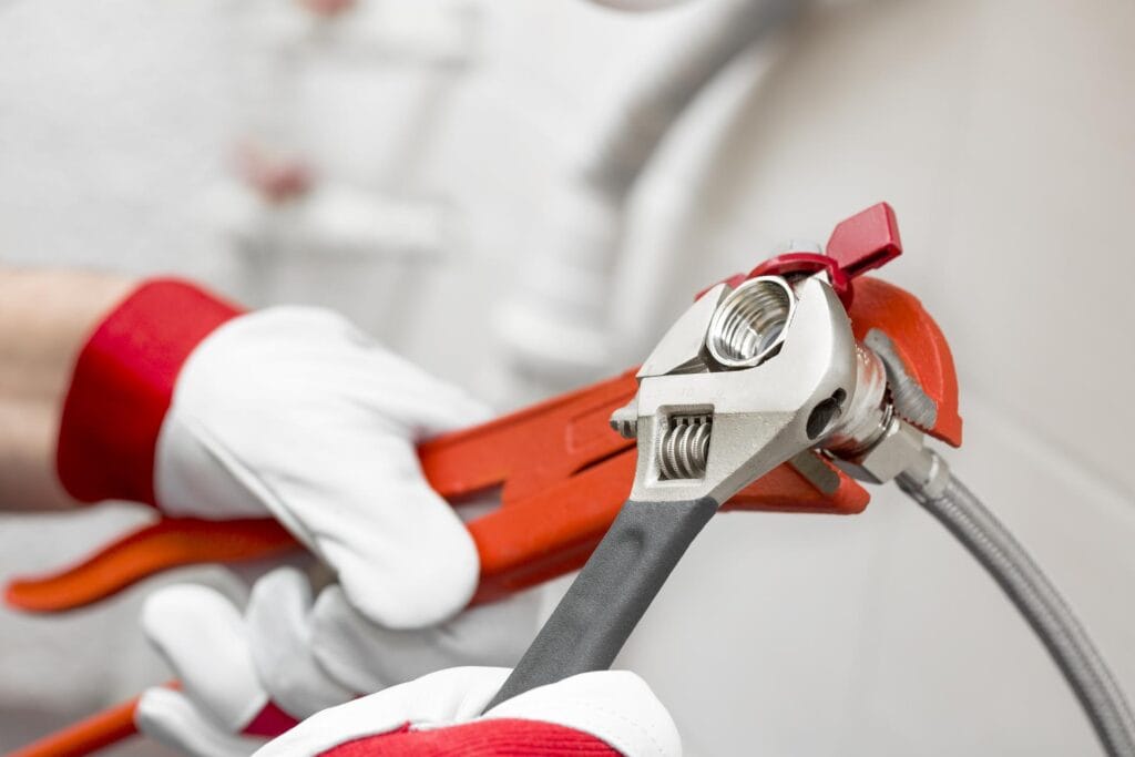 Plumber holding pipe wrenches for an emergency repair in DeBary