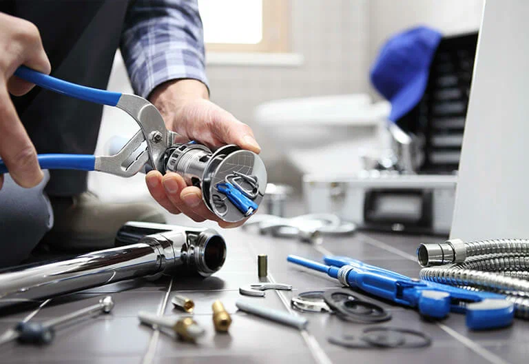 Technician repairing a plumbing fixture with professional tools in DeBary