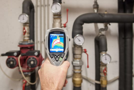 Plumber using a thermal imaging camera to inspect pipes in DeBary