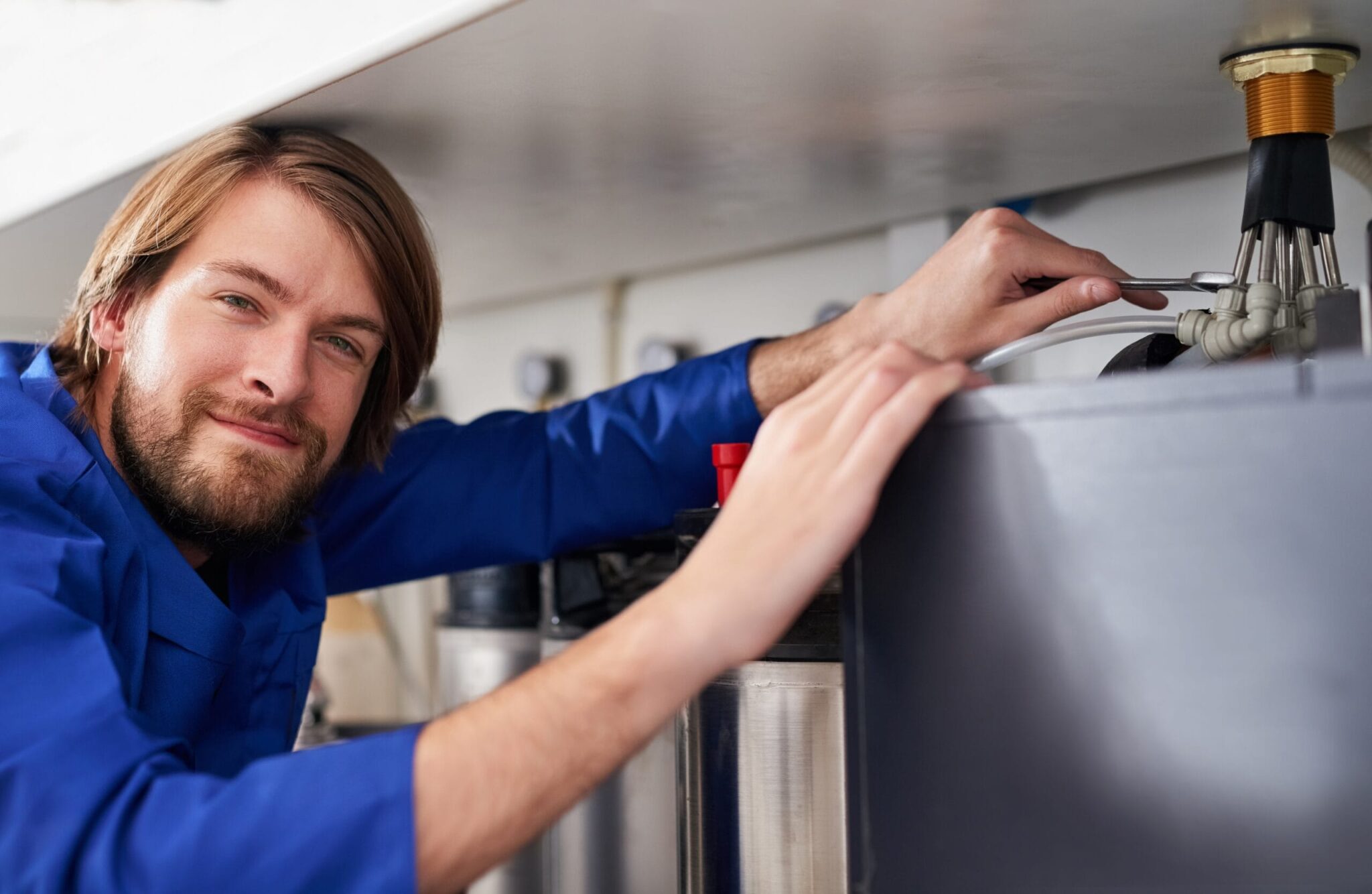 Technician servicing a residential water heater tank in DeBary